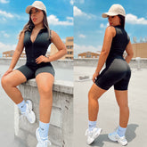 Mujer usando enterizo corto deportivo negro de suplex premium con cierre frontal y cuello alzado en exterior urbano