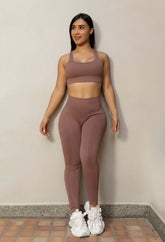 Conjunto deportivo seamless mujer en lycra texturizada color marrón, top push up y leggins moldeadores sin costuras.