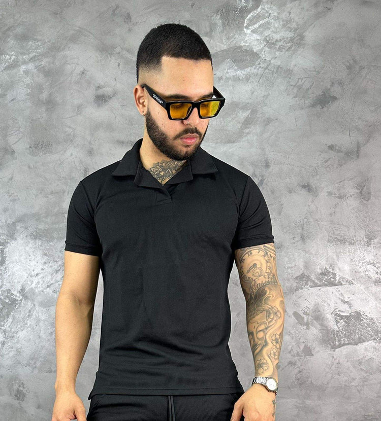 Hombre con camiseta polo texturizada beige de algodón, estilo clásico y moderno, frente a fondo gris