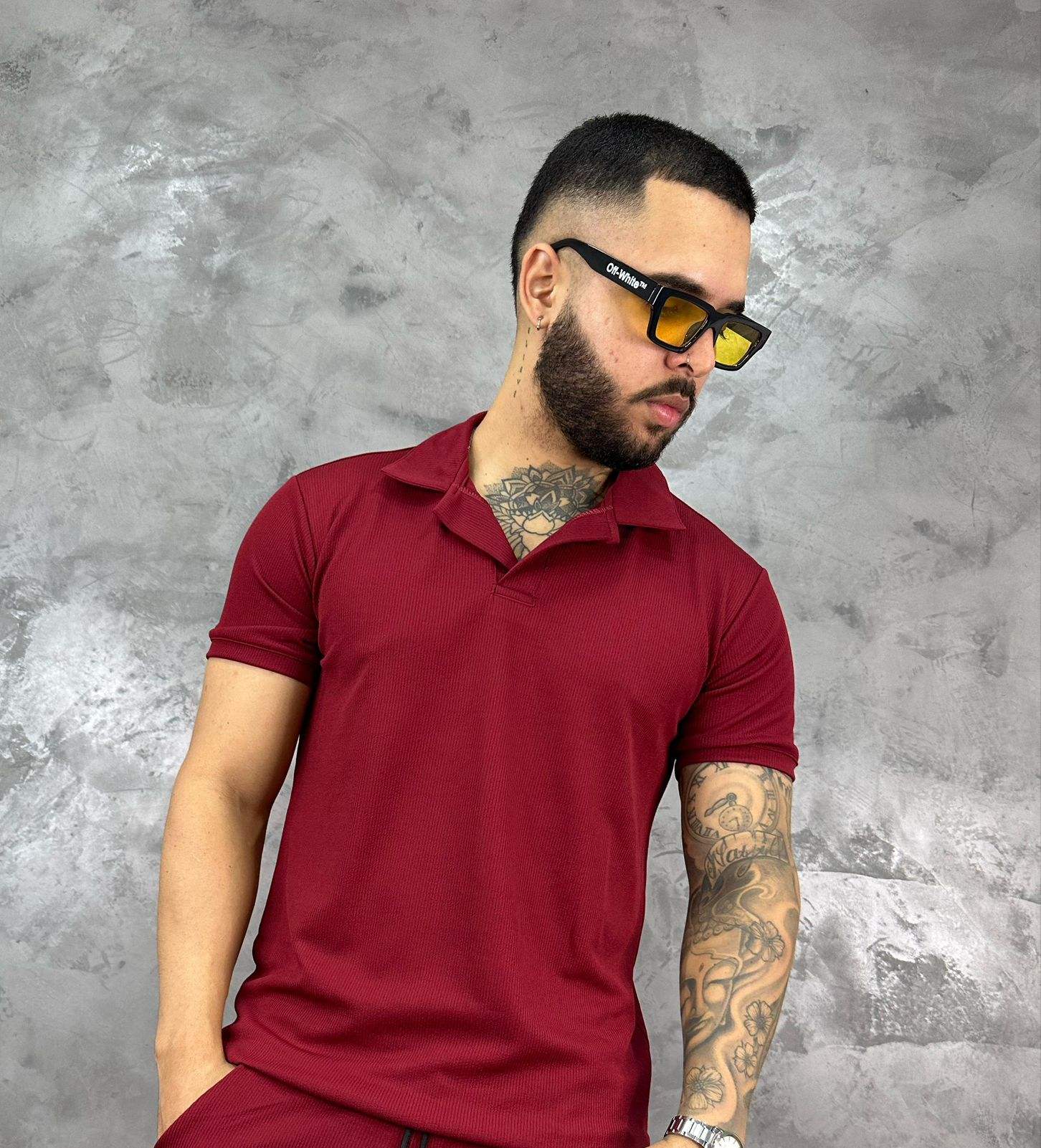 Hombre con camiseta polo texturizada beige de algodón, estilo clásico y moderno, frente a fondo gris