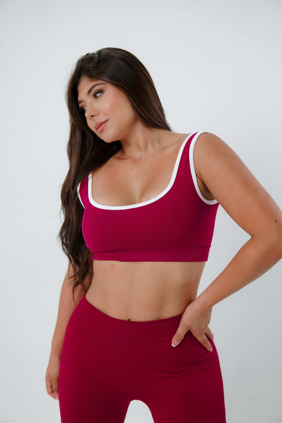Mujer con Top Deportivo Seamless berenjena de compresión y diseño sin costuras.