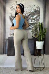 Mujer posando con conjunto pantalón y blusa en bengalina licrada, elegante y ajustado, color beige y azul.
