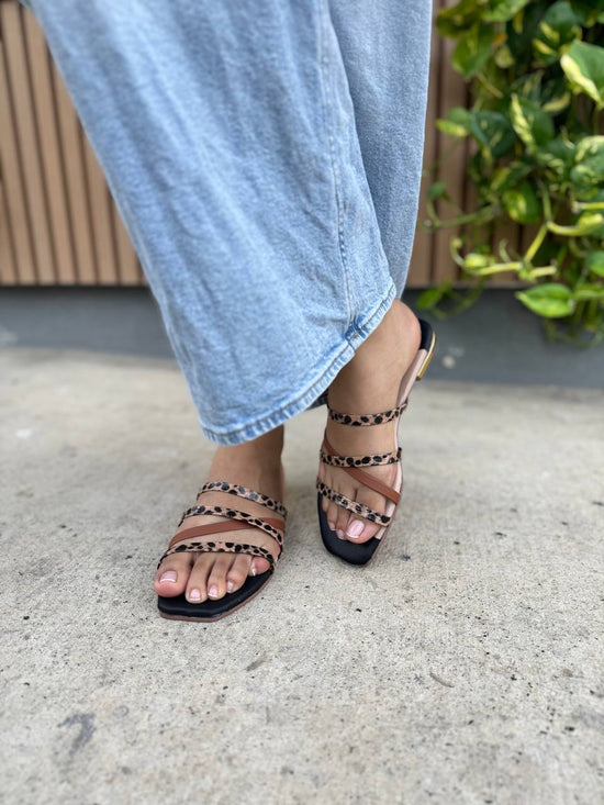 Sandalia Plana Cruzzi para mujer con tiras entrelazadas y diseño animal print, suela de PVC liviano y tacón plano.